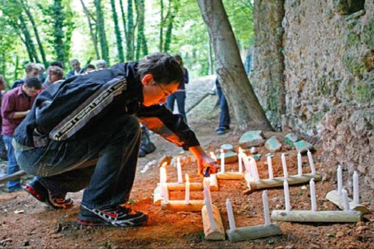 Junge entzündet Kerzen zum Gedenken an die Opfer in Sant Anna.